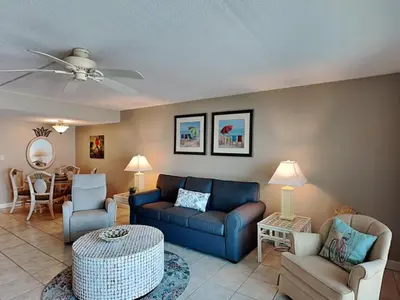 a living room with a blue couch and chairs at Mariner East #306 in Panama City Beach