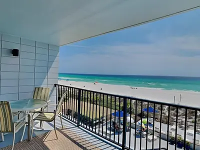 a balcony with a table and chairs and the beach at Mariner East #306 in Panama City Beach