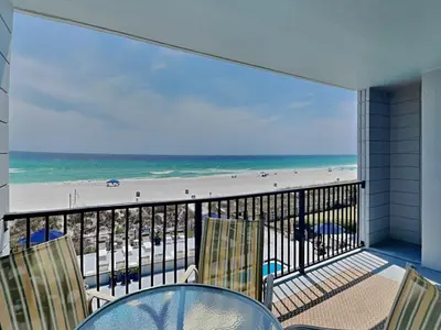 a balcony with a table and chairs and a beach at Mariner East #306 in Panama City Beach
