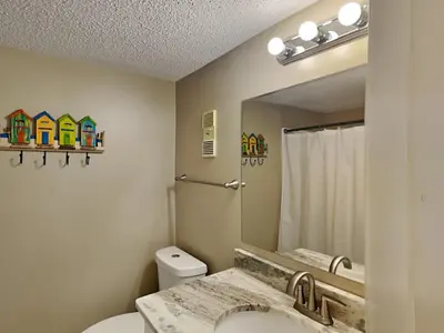 a bathroom with a toilet and a sink and a mirror at Mariner East #306 in Panama City Beach