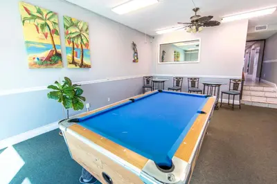 a room with a pool table in it with chairs at Mariner East #306 in Panama City Beach