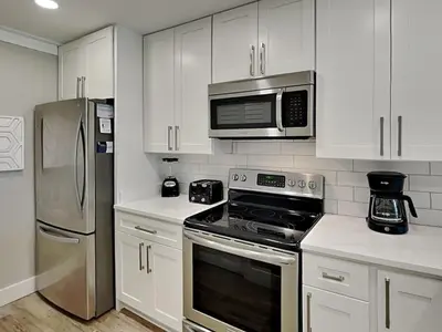 a kitchen with white cabinets and stainless steel appliances at Edgewater Villa #909 in Panama City Beach