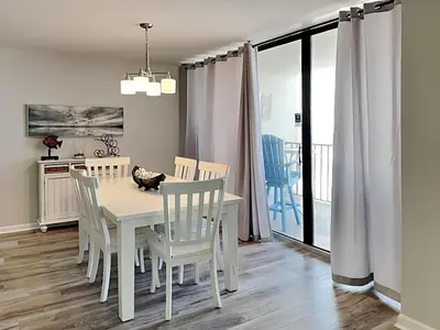 a dining room with a white table and chairs at Edgewater Tower II #606 in Panama City Beach