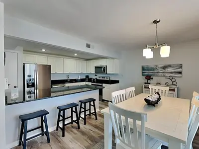 a kitchen and dining room with a table and chairs at Edgewater Tower II #606 in Panama City Beach