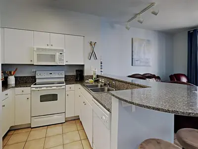 a kitchen with white cabinets and a counter top at Shores of Panama #1423 in Panama City Beach