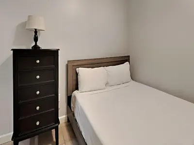 a bedroom with a bed and a dresser with a lamp at Shores of Panama #1423 in Panama City Beach