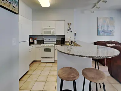 a kitchen with a counter and a table and chairs at Shores of Panama #1423 in Panama City Beach