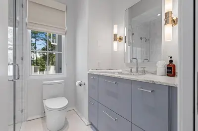 a bathroom with a toilet and a sink and a window at Oceanview Oasis in Seagrove Beach