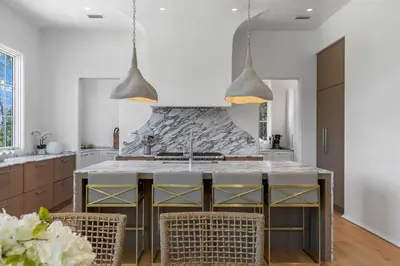 a kitchen with a counter with chairs and a sink at Oceanview Oasis in Seagrove Beach