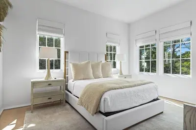 a white bedroom with a bed and two windows at Oceanview Oasis in Seagrove Beach