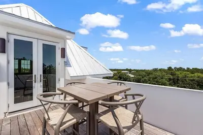 a wooden table and chairs on a balcony at Oceanview Oasis in Seagrove Beach