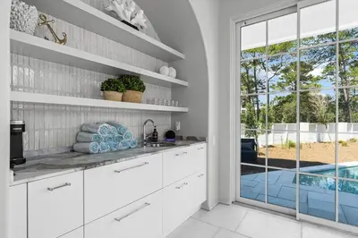 a kitchen with white cabinets and a large window at Oceanview Oasis in Seagrove Beach