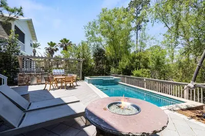 a backyard with a pool with a table and a fire pit at Gone Coastal in Santa Rosa Beach
