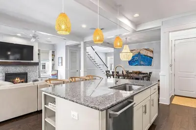 a kitchen with a counter top and a living room at Gone Coastal in Santa Rosa Beach