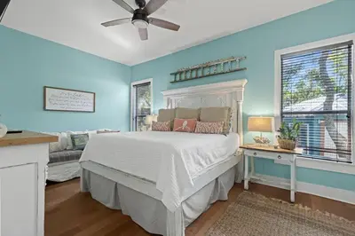 a bedroom with a white bed and blue walls at Let It Be in Inlet Beach