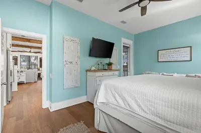 a bedroom with a bed and a tv on the wall at Let It Be in Inlet Beach