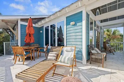 a patio with a table and chairs and an umbrella at Let It Be in Inlet Beach