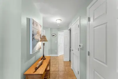 a hallway with a table with a lamp on it at Stunning 3BR Corner Tidewater Resort Beachfront Condo! Sleeps 10! by Dolce Vita Getaways PCB! in Panama City Beach