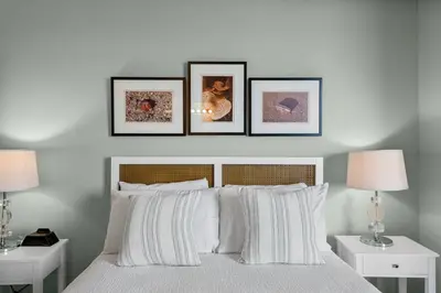 a bedroom with three framed pictures above a bed at Stunning 3BR Corner Tidewater Resort Beachfront Condo! Sleeps 10! by Dolce Vita Getaways PCB! in Panama City Beach