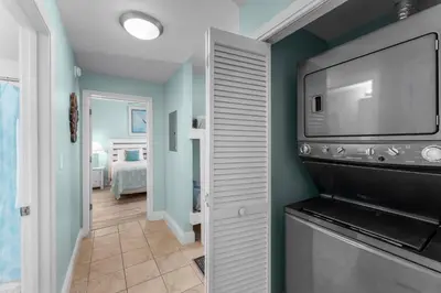 a room with a tv and a hallway with a bedroom at Family and Friends Beach Resort Condo for 8! Steps from the Beach! By Dolce Vita Getaways! in Panama City Beach