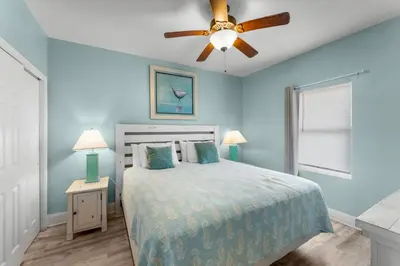 a blue bedroom with a bed and a ceiling fan at Family and Friends Beach Resort Condo for 8! Steps from the Beach! By Dolce Vita Getaways! in Panama City Beach