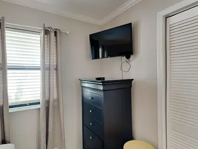 a bedroom with a dresser and a television on a wall at Edgewater Villa #2601 in Panama City Beach