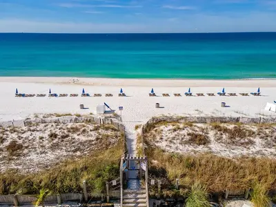 a beach with a bunch of sail boats on it at Sugar Beach Condo B-14 by Emerald Coast Retreats in Panama City Beach