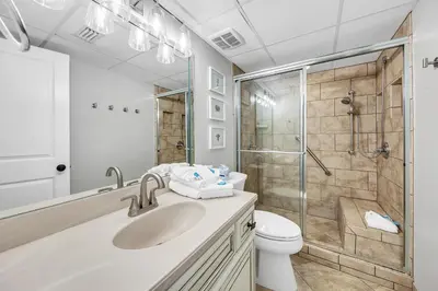 a bathroom with a shower and a sink and a toilet at Sugar Beach Condo B-14 by Emerald Coast Retreats in Panama City Beach
