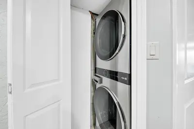 two washing machines in a cabinet next to a door at Sugar Beach Condo B-14 by Emerald Coast Retreats in Panama City Beach
