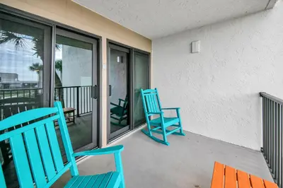 two blue chairs sitting on the balcony of a house at Sugar Beach Condo B-14 by Emerald Coast Retreats in Panama City Beach