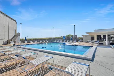 a swimming pool with lounge chairs in a building at Sugar Beach Condo B-14 by Emerald Coast Retreats in Panama City Beach