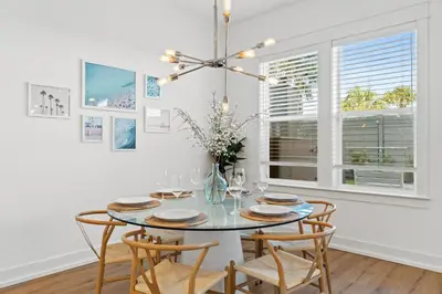 a dining room with a glass table and chairs at Take It Easy by Book That Condo in Panama City Beach