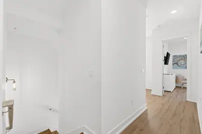 a white room with white walls and wooden floors at Take It Easy by Book That Condo in Panama City Beach