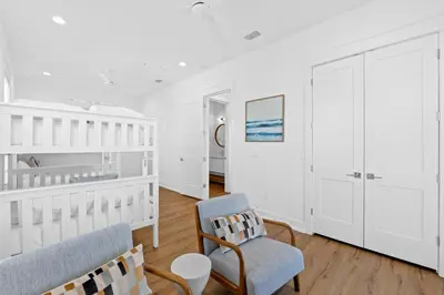 a white nursery with two chairs and a crib at Take It Easy by Book That Condo in Panama City Beach