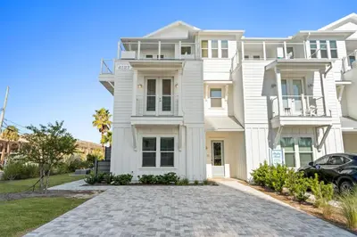 a white house with a car parked in front of it at Take It Easy by Book That Condo in Panama City Beach