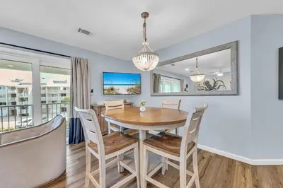 a dining room and living room with a table and chairs at Beachside Villas 832 in Santa Rosa Beach