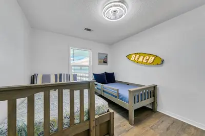 a bedroom with a bed and a bench and a window at Beachside Villas 832 in Santa Rosa Beach