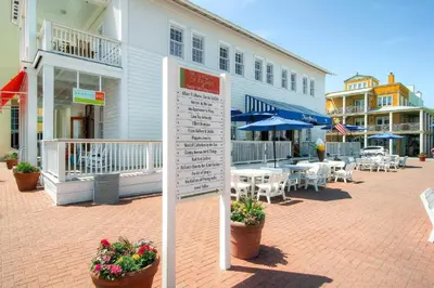 a sign in front of a building with tables and chairs at Beachside Villas 832 in Santa Rosa Beach