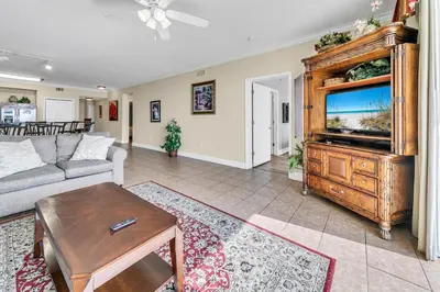 a living room with a couch and a tv at Tidewater 1902 in Panama City Beach