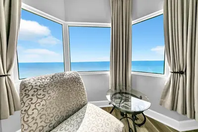 a room with a chair in front of a window at Tidewater 1902 in Panama City Beach