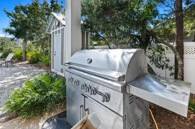 a barbecue grill in a backyard with a patio at Forever Five O'Clock in Seacrest
