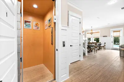 a hallway with a white door and a dining room at Forever Five O'Clock in Seacrest