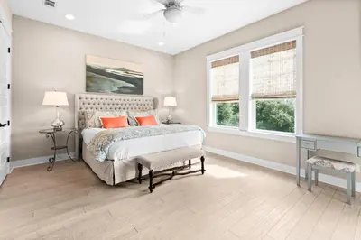 a bedroom with a bed and two windows at Forever Five O'Clock in Seacrest