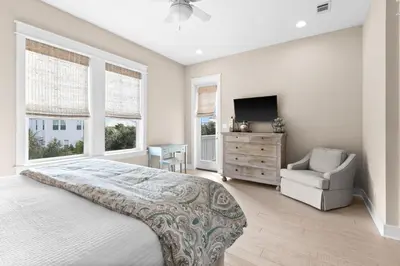 a bedroom with a bed and a chair and a television at Forever Five O'Clock in Seacrest