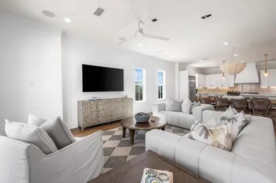 a living room with white furniture and a flat screen tv at 30A Sunrise 6 Bedroom in Santa Rosa Beach