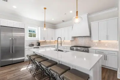 a kitchen with white cabinets and a large kitchen island at 30A Sunrise 6 Bedroom in Santa Rosa Beach