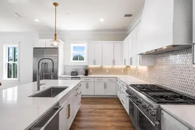 a white kitchen with a sink and a stove at 30A Sunrise 6 Bedroom in Santa Rosa Beach