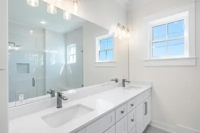 a white bathroom with two sinks and a large mirror at 30A Sunrise 6 Bedroom in Santa Rosa Beach