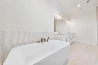 a white bathroom with a large tub and a sink at 30A Sunrise 6 Bedroom in Santa Rosa Beach