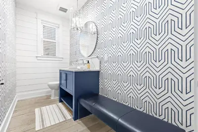 a bathroom with a blue bench and a mirror at Sunset Serenity in Panama City Beach